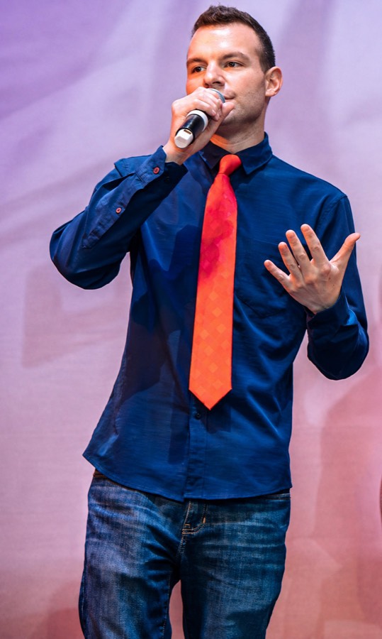 Drew Wofford on stage with a microphone.